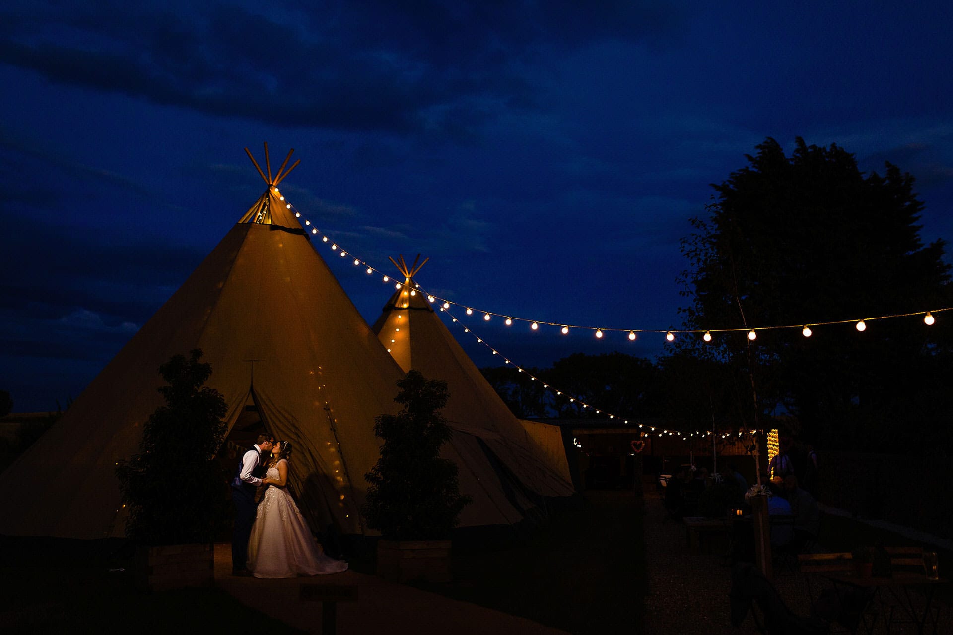 A couple kiss at their Scarborough tipi wedding. Fun and creative wedding photography by Emma + Rich