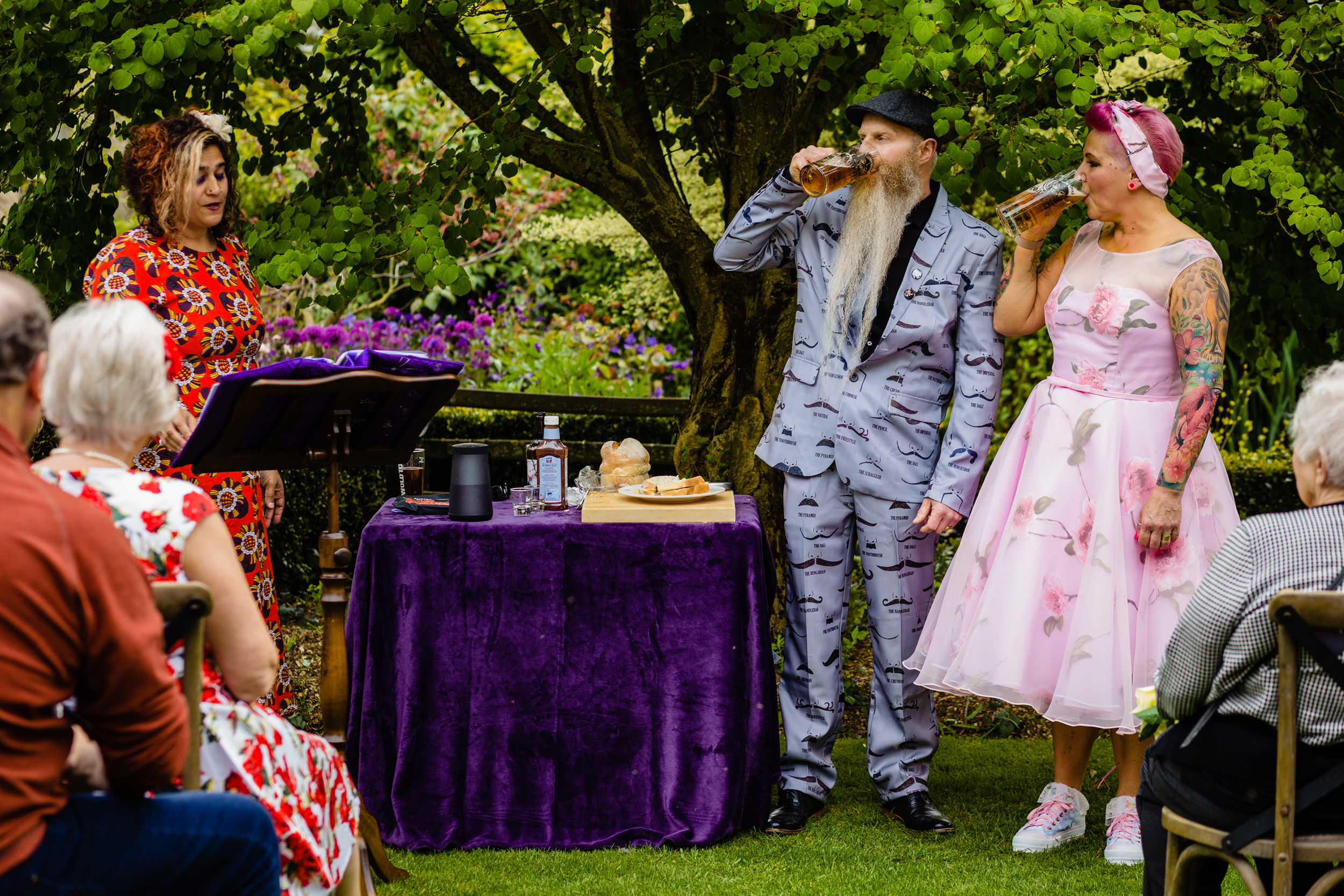 bride and groom drinking pints during the ceremony. wold top brewery wedding photography by emma and rich.