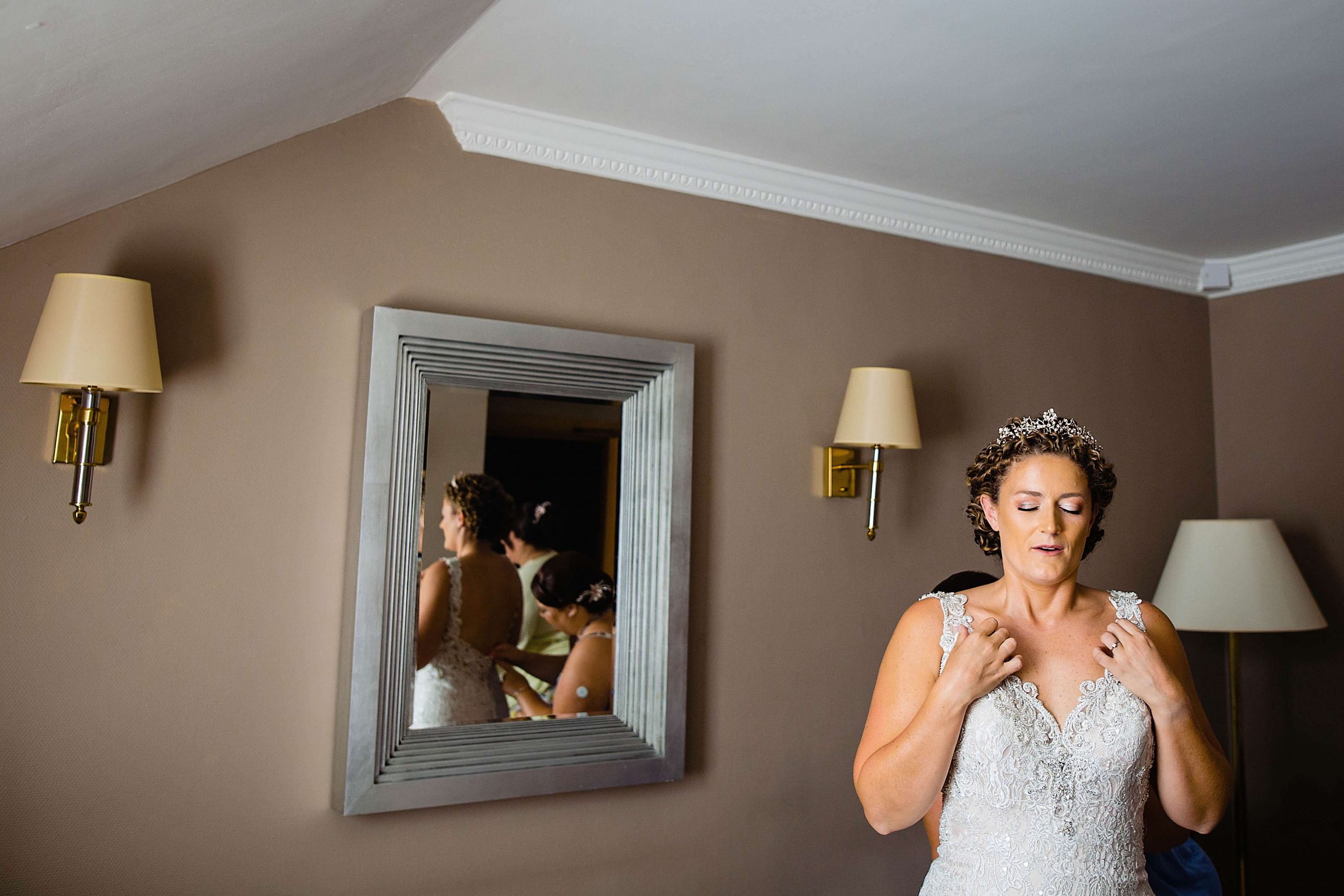 bride takes a deep breath as she dresses for her wedding. woodstock weddings and events wedding photography by emma and rich