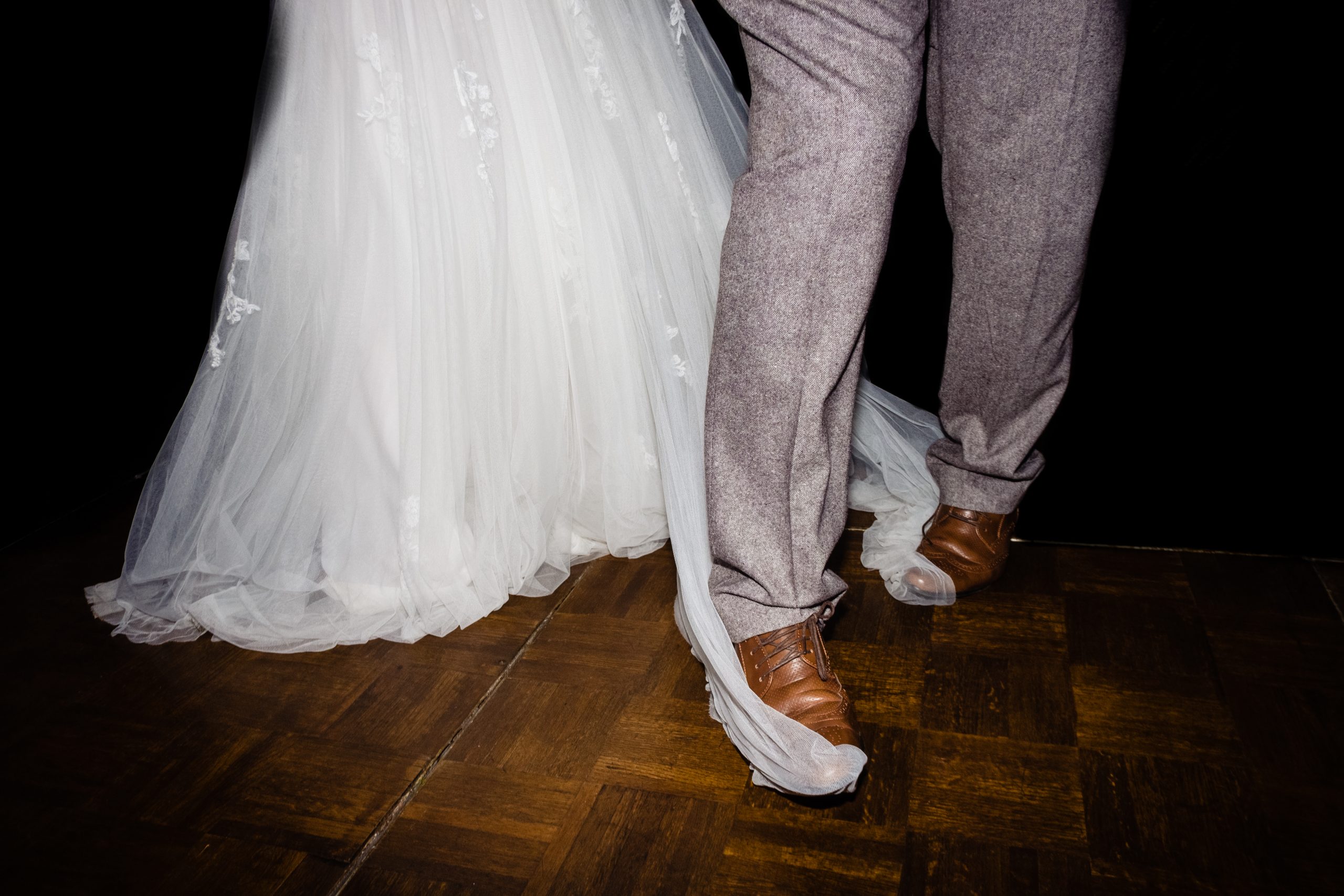 a man's feet are tangled up in the wedding dress on the dance floor. rangefinder 30 rising stars emma and rich.