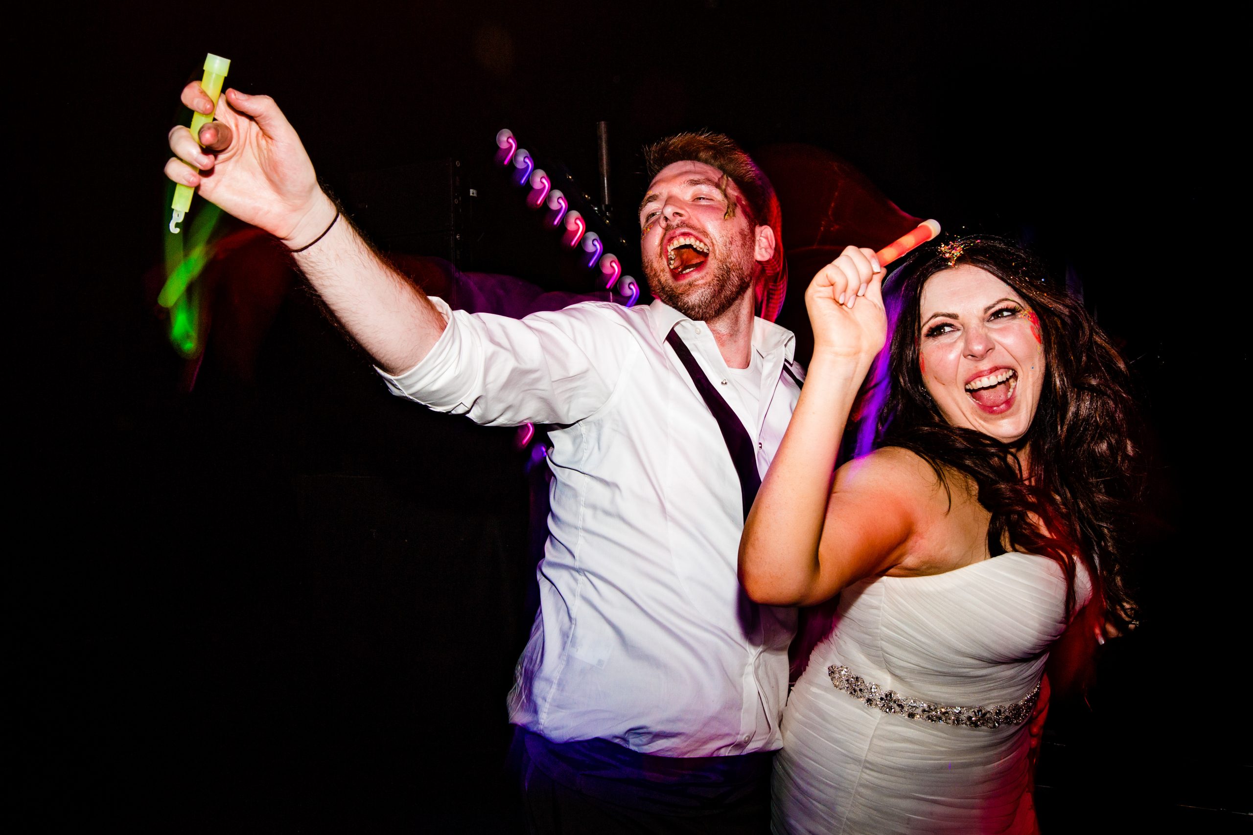 a bride and groom raving with glow sticks.