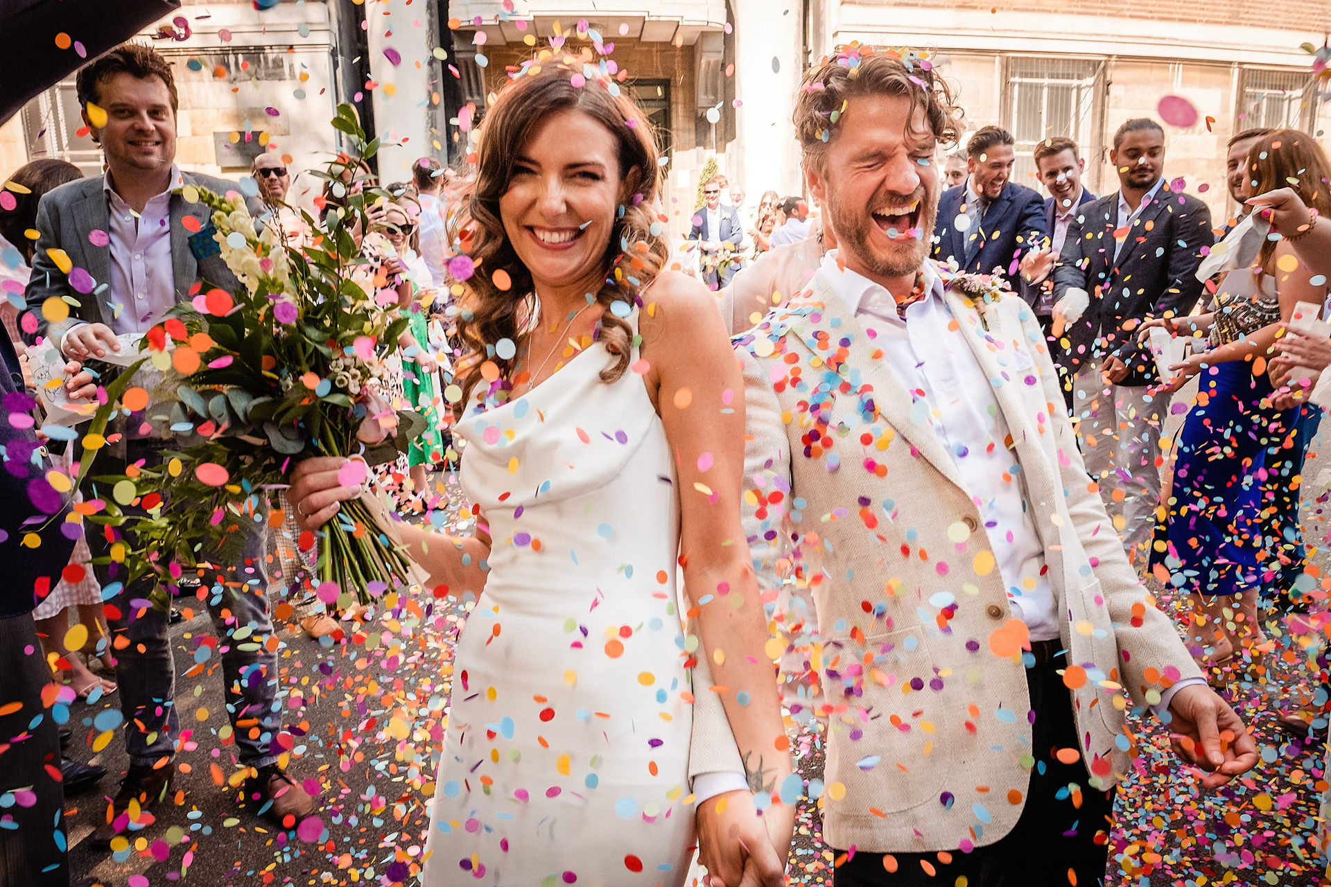 bride and groom under confetti leaving a london town hall wedding, a london wedding venue