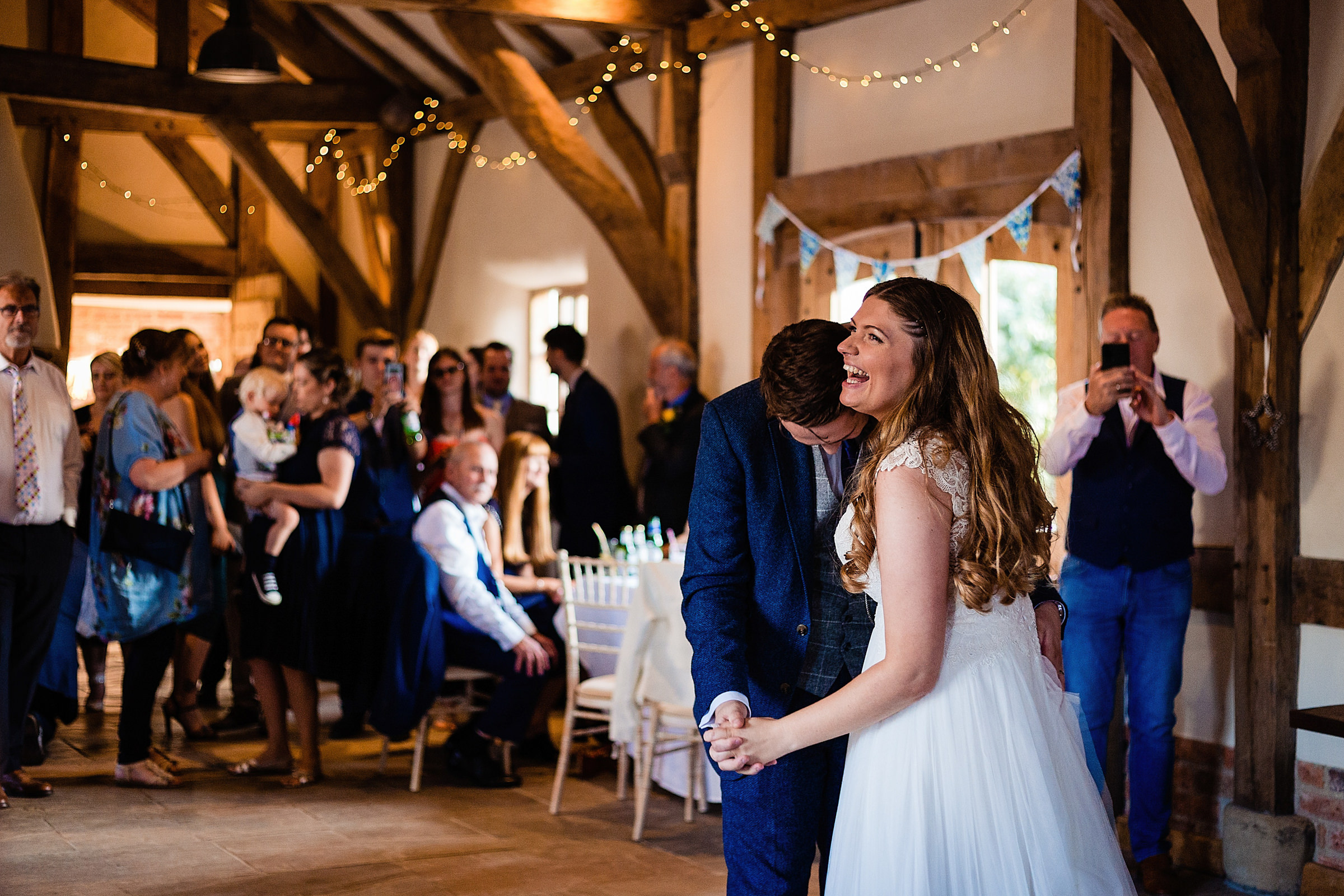 Bride and groom laughing while enjoying their first dance at Abbey Farm Weddings.