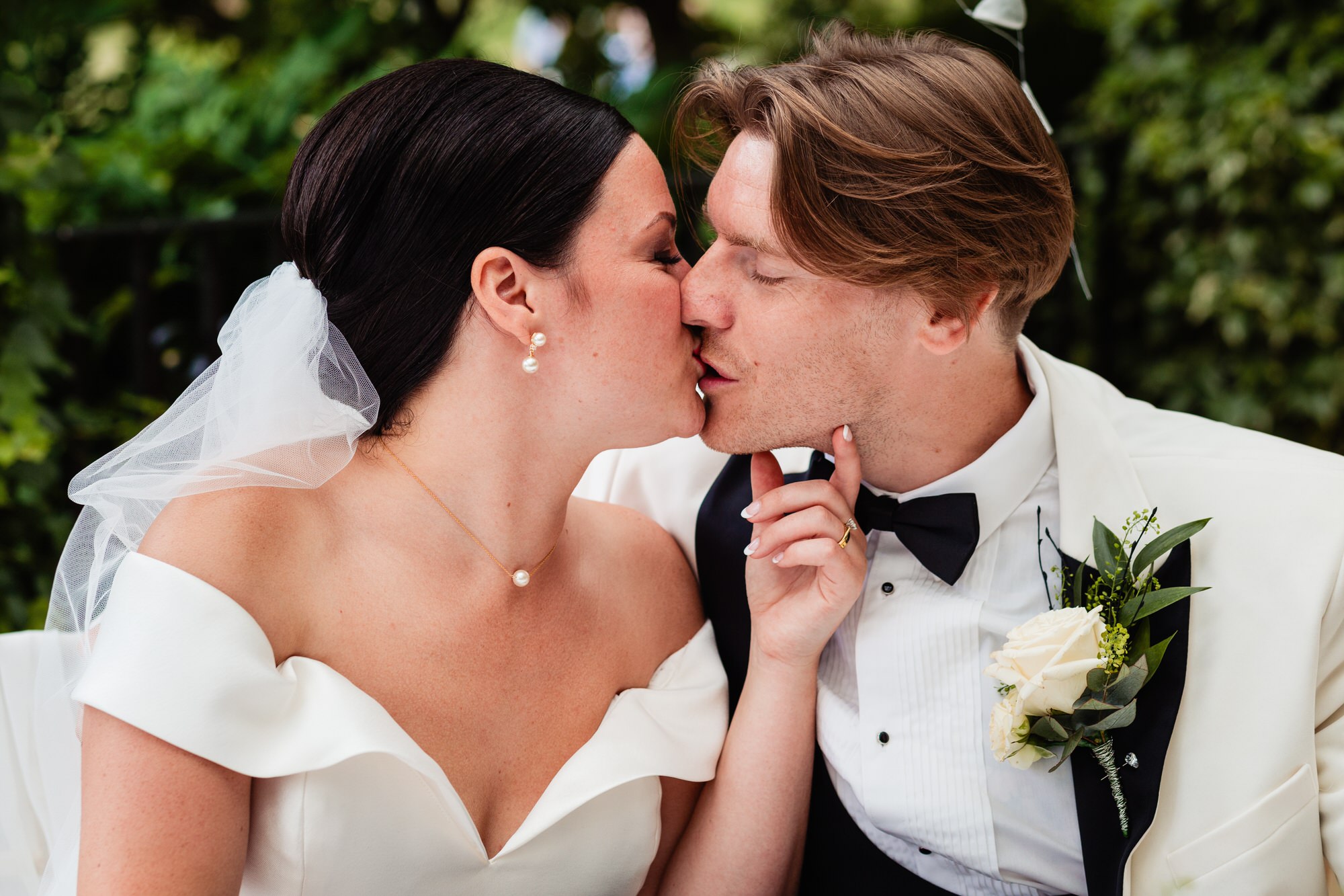 a bride and groom kiss as they sign the wedding register. sun pavilion Harrogate wedding photography by emma and rich.